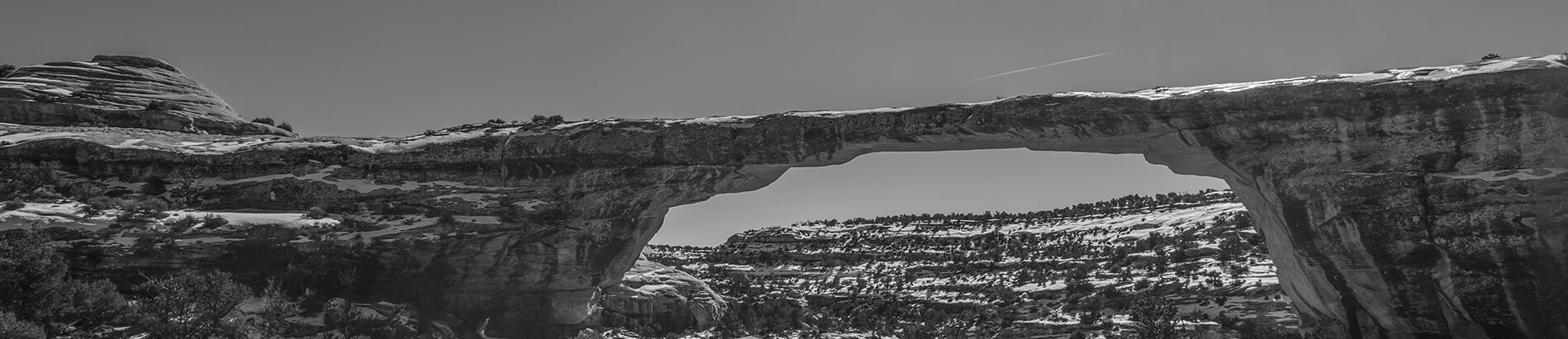 grayscale nature made rock bridge
